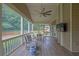 A relaxing screened porch features a ceiling fan, tv, and ample seating at 1304 Swallows Walk, Grayson, GA 30017