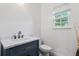 Bathroom featuring dark blue vanity, marble countertop, and ample lighting at 1657 Bradmere Ln, Lithia Springs, GA 30122