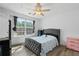 Bright bedroom features a window view, ceiling fan, and a tufted-frame bed at 1657 Bradmere Ln, Lithia Springs, GA 30122
