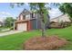 Two-story home with gray siding, brick facade, two-car garage, and spacious front lawn at 1657 Bradmere Ln, Lithia Springs, GA 30122