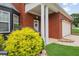 Charming brick home featuring a covered front porch with classic white columns and manicured landscaping at 1657 Bradmere Ln, Lithia Springs, GA 30122