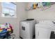 Well-lit laundry room features modern washer and dryer, storage shelving, and cleaning supplies at 1657 Bradmere Ln, Lithia Springs, GA 30122