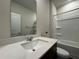 Bathroom featuring a sleek white vanity and a shower-tub combination for a modern touch at 2277 Whitworth St, Lawrenceville, GA 30044
