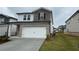 Two-story home with a white garage door, brick and stone accents, and a manicured lawn at 2277 Whitworth St, Lawrenceville, GA 30044