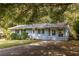 Charming single story house with light blue painted brick, mature trees and an asphalt driveway at 2849 Crescendo Dr, Atlanta, GA 30318