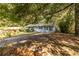 Charming single story house with light blue painted brick, mature trees and a concrete driveway at 2849 Crescendo Dr, Atlanta, GA 30318