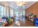 This living room features a ceiling fan, hardwood floors, several windows and a brick wall at 2849 Crescendo Dr, Atlanta, GA 30318