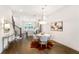 Elegant dining area featuring hardwood floors, a modern chandelier, and access to kitchen and living room at 4202 Deming Cir, Sandy Springs, GA 30342