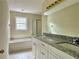 Bathroom featuring a double sink vanity, soaking tub, shower, and tiled flooring at 4970 Clubgreen Smt, Stone Mountain, GA 30088