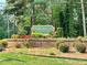 Fairgreen at Hidden Hills community sign surrounded by flowers and greenery atop a brick base at 4970 Clubgreen Smt, Stone Mountain, GA 30088