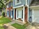 Inviting front porch with white columns, a bright white door, and well manicured lawn at 4970 Clubgreen Smt, Stone Mountain, GA 30088