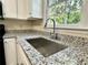 Kitchen sink with granite countertops, white cabinets and a view to the back yard at 4970 Clubgreen Smt, Stone Mountain, GA 30088