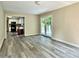Living room with gray vinyl floors, neutral walls with a view to the kitchen and deck at 4970 Clubgreen Smt, Stone Mountain, GA 30088