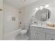 Bathroom featuring bright white cabinets and tile, gold fixtures and trim, and a round mirror at 2139 Logan Dr, Jonesboro, GA 30236