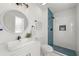 Stylish bathroom with modern vanity, round mirror, and sleek walk-in shower with blue tile accent at 2139 Logan Dr, Jonesboro, GA 30236