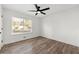 Minimalist bedroom design, featuring a ceiling fan, hardwood style flooring, and a large window at 2139 Logan Dr, Jonesboro, GA 30236