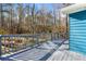 Back deck of home with grey floors and blue siding overlooks a wooded area at 2139 Logan Dr, Jonesboro, GA 30236