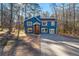 Charming two-story home with a blue exterior, complemented by a spacious front yard and mature trees at 2139 Logan Dr, Jonesboro, GA 30236