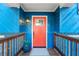 Inviting entrance featuring a vibrant orange door, blue siding, and a charming wooden porch at 2139 Logan Dr, Jonesboro, GA 30236
