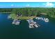 Aerial view of a lake marina with several boats docked, surrounded by dense forestry and scenic landscapes at 3265 Greenhill Ct, Villa Rica, GA 30180