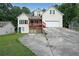 Charming multi-story home boasts a red porch, lush surroundings, and convenient driveway access to the garage at 3265 Greenhill Ct, Villa Rica, GA 30180