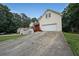 Multi-story home with a red porch, long driveway, and attached garage, set amongst green trees and landscaping at 3265 Greenhill Ct, Villa Rica, GA 30180