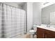 Bright bathroom featuring a shower with a gray and white striped curtain, and a wooden vanity at 3690 Lambert Ne Ln, Atlanta, GA 30319