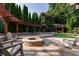 Outdoor fire pit area with stone seating, a pergola, and a grill, perfect for gatherings at 3690 Lambert Ne Ln, Atlanta, GA 30319