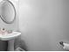 This stylish powder room features a pedestal sink with an oval mirror and modern fixtures at 3690 Lambert Ne Ln, Atlanta, GA 30319