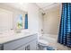Clean bathroom with blue shower curtain, vanity with sink, toilet, and tiled tub surround at 639 Tigers Eye Ter, Kennesaw, GA 30144