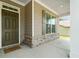 A cozy covered porch with stone accents, siding, a window, and a painted front door at 151 Rolling Hills Pl, Canton, GA 30114