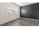 Minimalist bedroom with wood-look floors, a large window, and stylish accent wall at 2296 Waycross Ln, Dacula, GA 30019