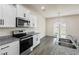 Bright kitchen featuring granite counters, stainless steel appliances, and modern white cabinetry at 2296 Waycross Ln, Dacula, GA 30019