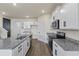 Open kitchen layout with white cabinets, granite countertops, and stainless steel appliances at 2296 Waycross Ln, Dacula, GA 30019