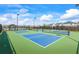 Community tennis courts with a blue and green playing surface and overhead lighting at 2296 Waycross Ln, Dacula, GA 30019