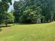 A lush backyard with a storage shed surrounded by mature trees offering privacy and shade at 3962 Chicamauga Ne Dr, Kennesaw, GA 30144