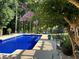 Private pool area with mature landscaping, lounge chairs, and an outdoor dining set at 3962 Chicamauga Ne Dr, Kennesaw, GA 30144