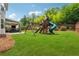 Spacious backyard with a wooden playset, swings, a slide, and lush green lawn at 422 Silver Brook Dr, Woodstock, GA 30188