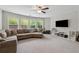 Spacious living room with carpeting, multiple windows, a ceiling fan, and entertainment area at 422 Silver Brook Dr, Woodstock, GA 30188