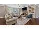 Cozy living room with built-in shelves, stone fireplace, and plush seating at 422 Silver Brook Dr, Woodstock, GA 30188