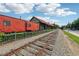 View of the train tracks with a red train car, historic building, and surrounding greenery in the Woodstock area at 422 Silver Brook Dr, Woodstock, GA 30188