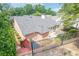 Brick home backyard with patio, manicured garden beds and black iron fencing at 10280 Medridge Cir, Johns Creek, GA 30022