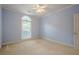 This bedroom features a window bringing in natural light, neutral carpet and a ceiling fan at 10280 Medridge Cir, Johns Creek, GA 30022