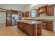Modern kitchen with an island, wooden cabinets, and stainless steel appliances at 10280 Medridge Cir, Johns Creek, GA 30022
