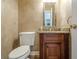 Powder room with stone-look walls, wood vanity and a granite countertop at 10280 Medridge Cir, Johns Creek, GA 30022