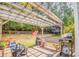 Backyard with patio, wooden pergola, and lush landscaping, ideal for outdoor relaxation and entertainment at 3288 Owens Meadow Ln, Kennesaw, GA 30152