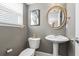 Stylish half bath features a pedestal sink, gold accents, and modern fixtures at 5880 Garden Circle Cir, Douglasville, GA 30135