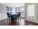 Bright dining room with hardwood floors, modern lighting, and adjacent door with natural light at 5880 Garden Circle Cir, Douglasville, GA 30135