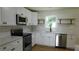 Bright kitchen featuring hardwood floors, white cabinets, quartz countertops, and stainless steel appliances at 9148 Homewood Dr, Riverdale, GA 30274