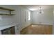 Bright kitchen with modern light fixture, hardwood floors, stainless steel dishwasher, and floating shelves at 9148 Homewood Dr, Riverdale, GA 30274